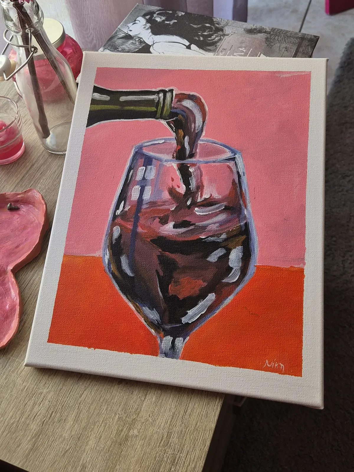 Wine pouring into a glass on a pink and orange background